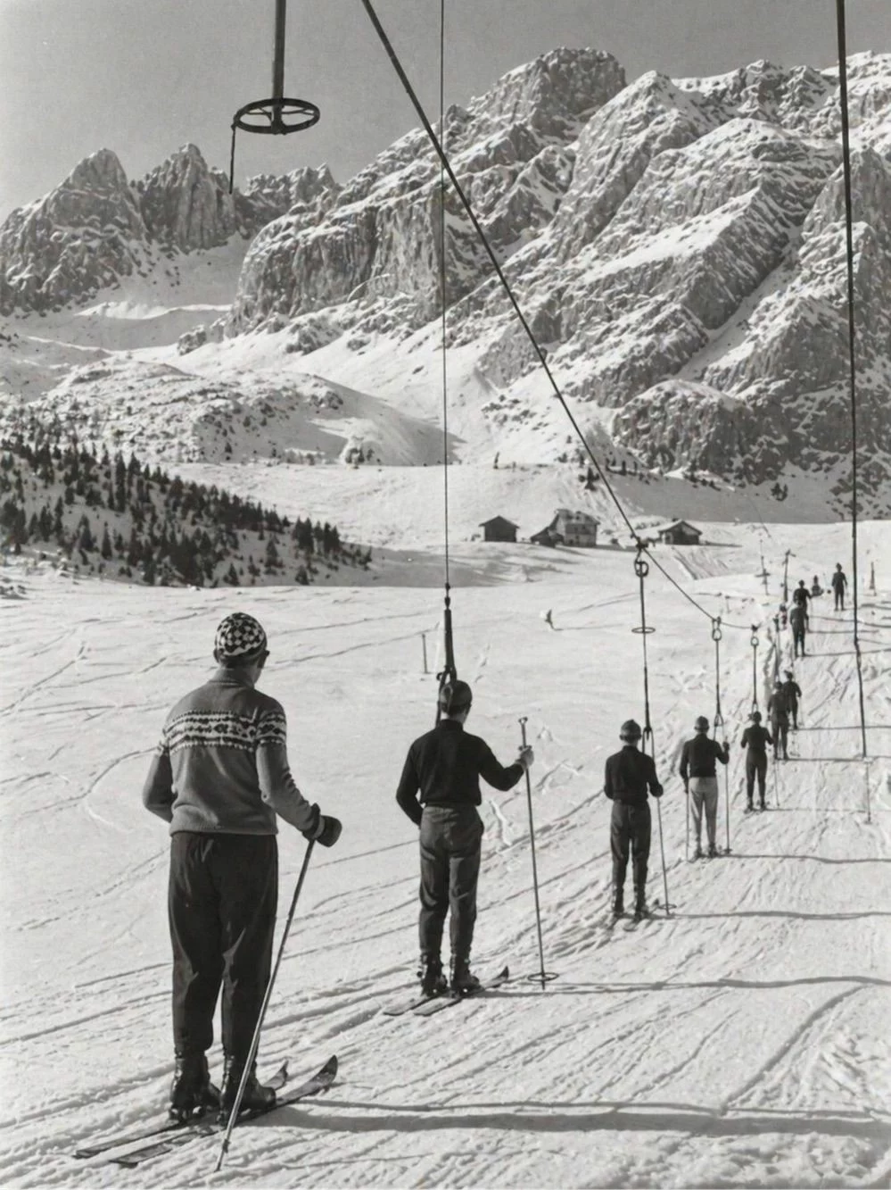 Foto in bianco e nero di serie di sciatori sulla sciovia.